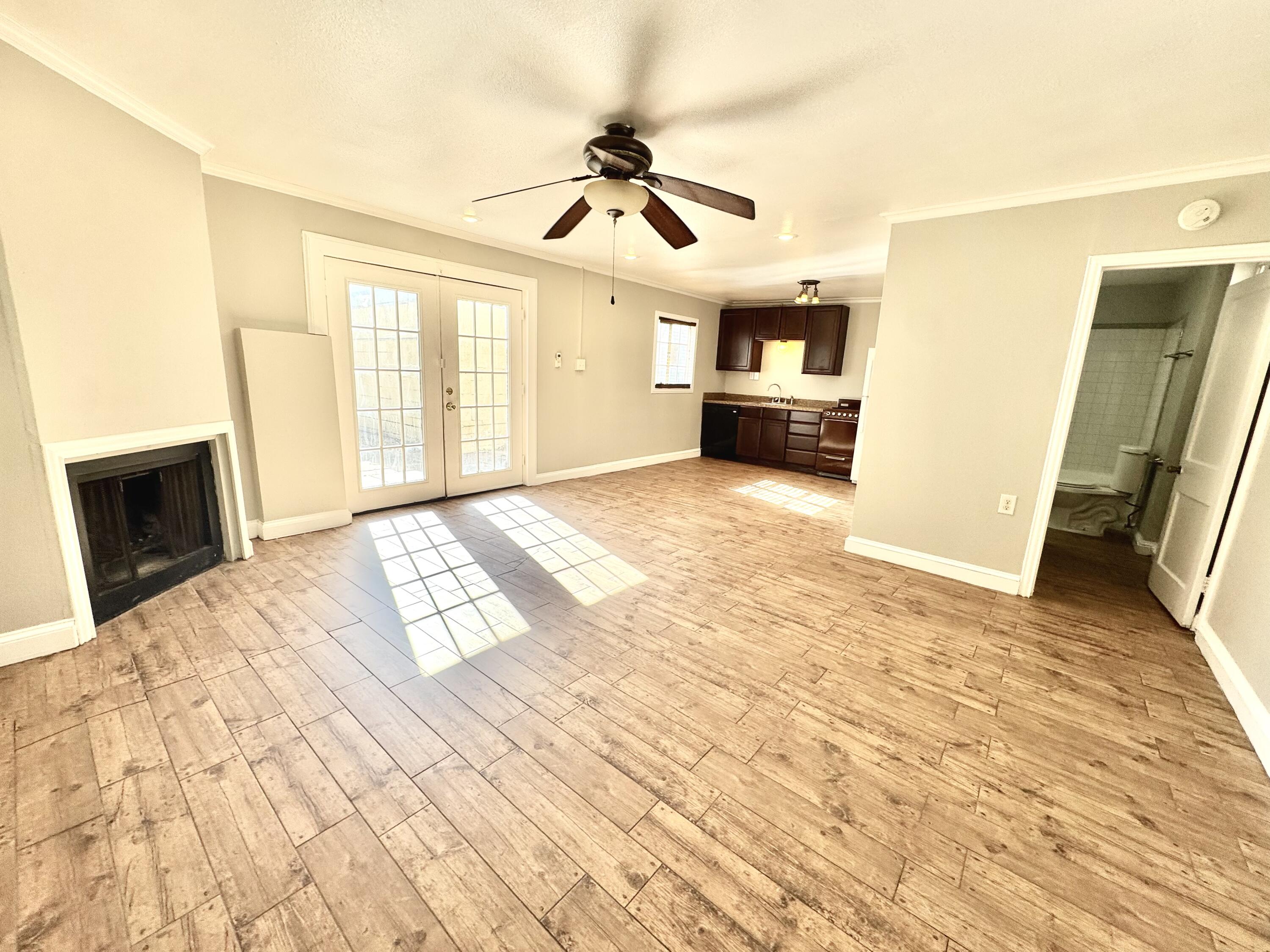 2702 23rd Street, Unit B Lubbock, TX 79410 - Photo 6 of 9 a view of a livingroom with wooden floor and a ceiling fan