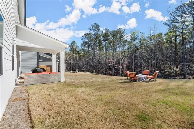 a view of a house with backyard and sitting area