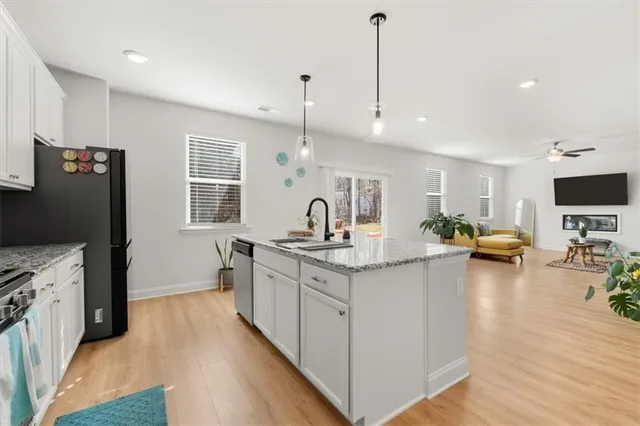 a kitchen with stainless steel appliances granite countertop a sink stove and wooden floor