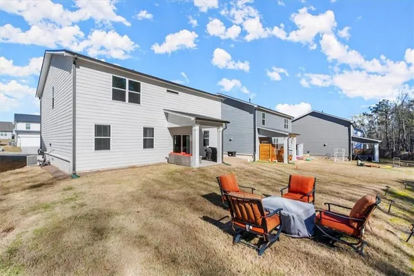 a view of a house with backyard and sitting area