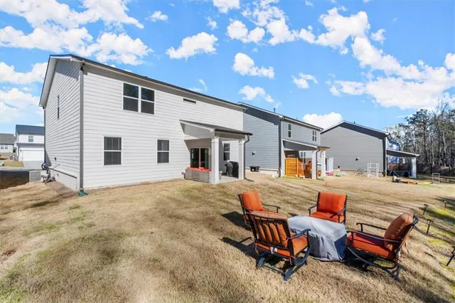 a view of a house with backyard and sitting area