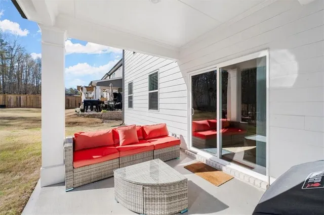 a living room with patio furniture and a rug