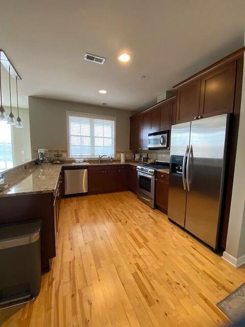 50 North Plum Grove Road, Unit 405 Palatine, IL 60067 - Photo 7 of 14 a large kitchen with kitchen island a sink stainless steel appliances and cabinets