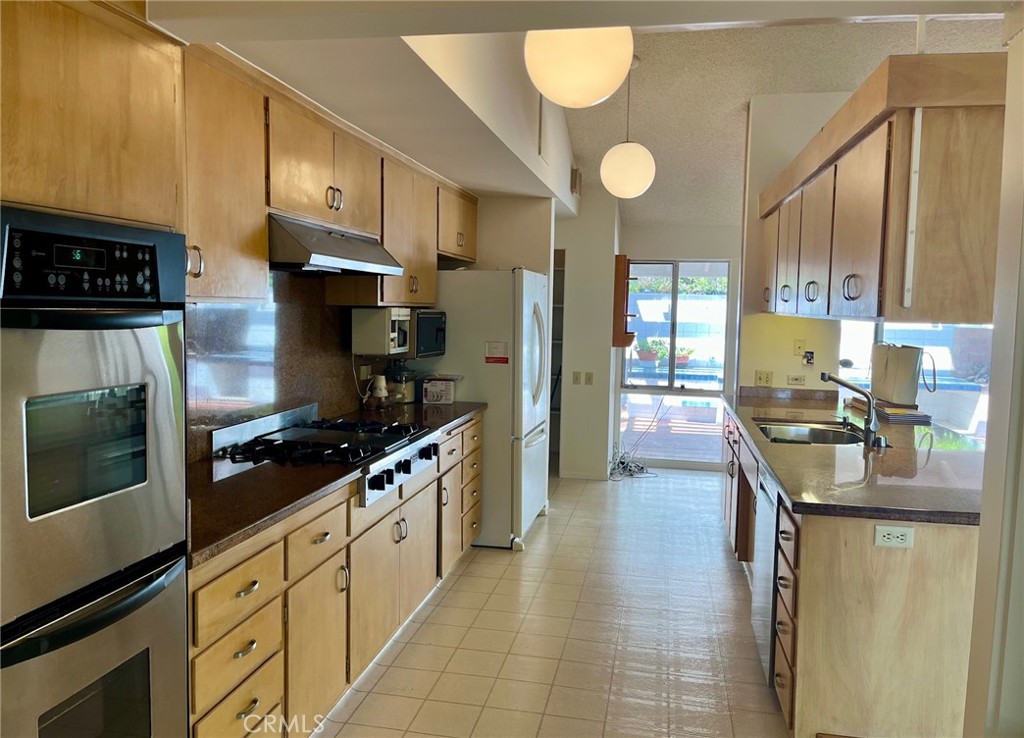 6349 Sycamore Meadows Drive Malibu, CA 90265 - Photo 4 of 10 a kitchen with stainless steel appliances granite countertop a stove refrigerator and cabinets