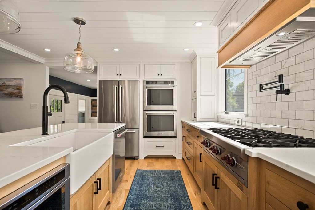 1 True Road Salisbury, MA 01952 - Photo 21 of 41 a kitchen with stainless steel appliances kitchen island a large stove a sink dishwasher and refrigerator with wooden floor