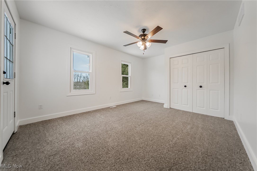 7488 Greenwich Road Seville, OH 44273 - Photo 15 of 37 Unfurnished bedroom featuring a closet, light carpet, and ceiling fan