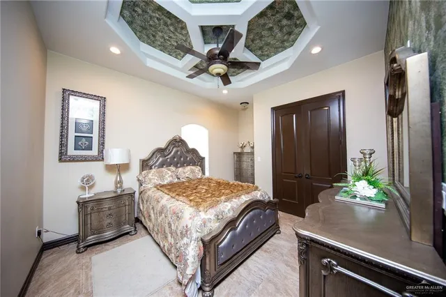 a bedroom with a bed ceiling fan and a wooden floor
