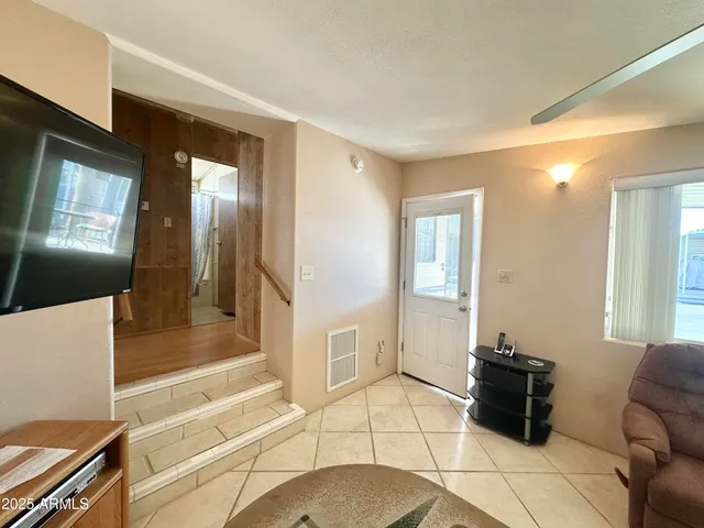 a living room with a flat screen tv on the wall and a potted plant