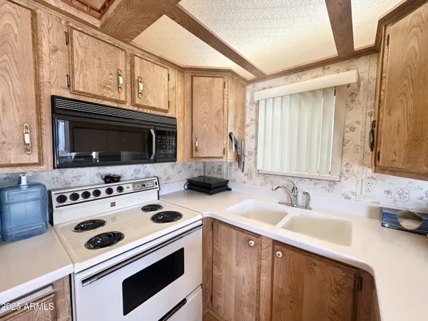 a large living room with stainless steel appliances granite countertop furniture and a wooden floor