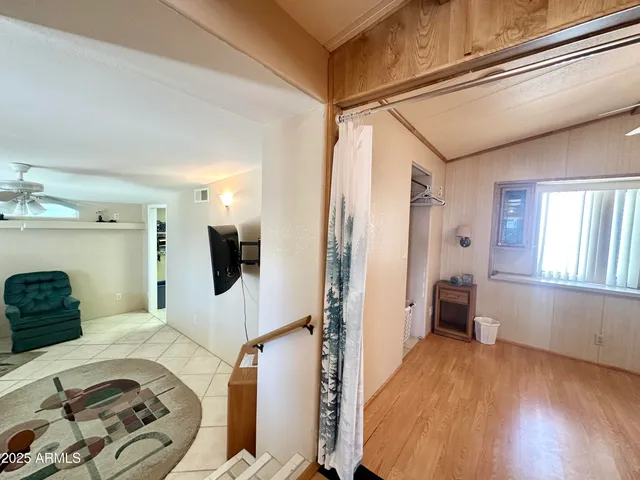 a view of walk in closet and chandelier fan