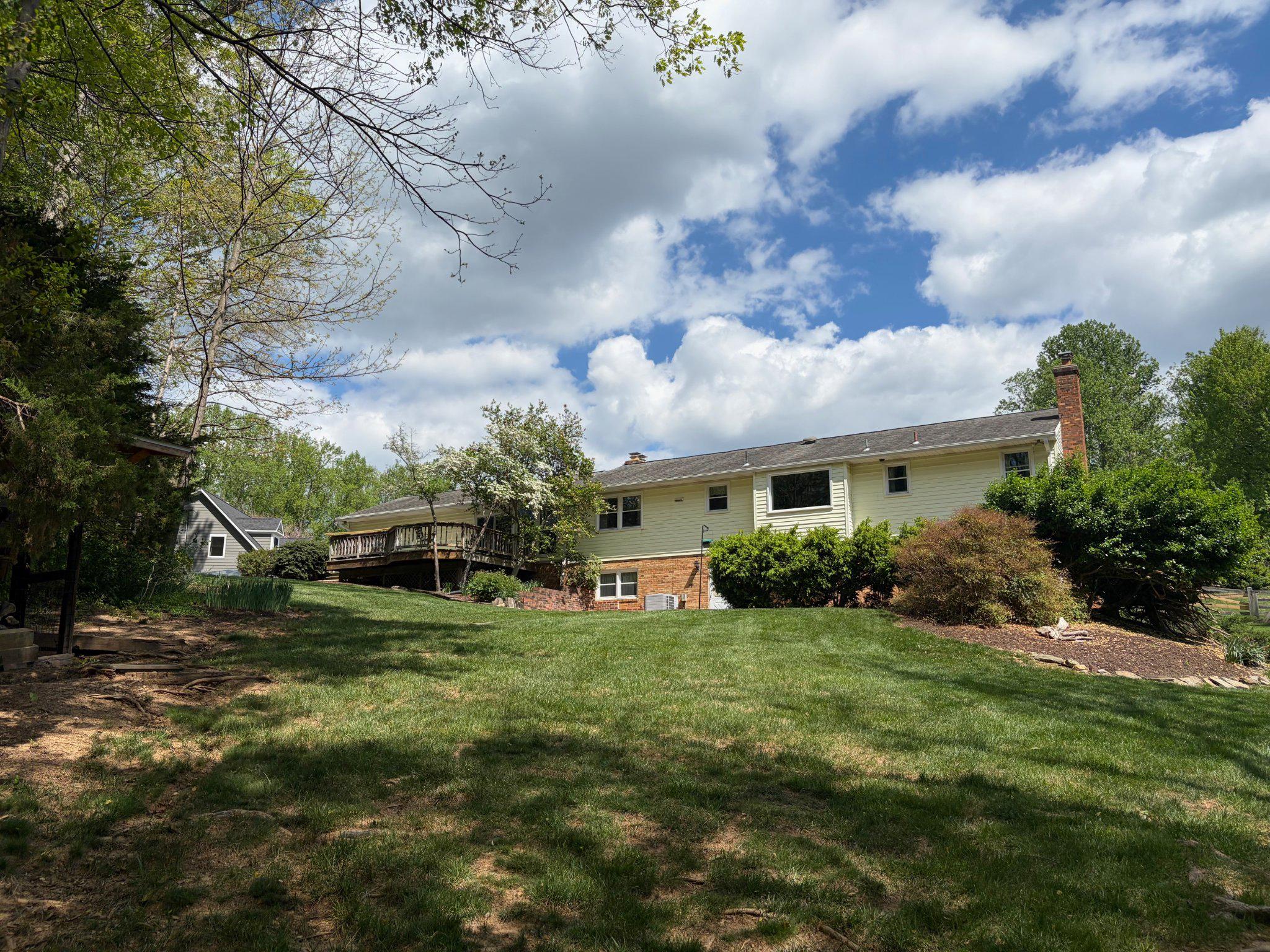 10425 Lake Ridge Drive Oakton, VA 22124 - Photo 3 of 5 a view of a house with a big yard and large trees