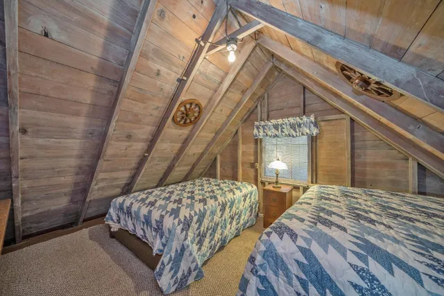 a bedroom with a bed a dresser and paintings on the wall