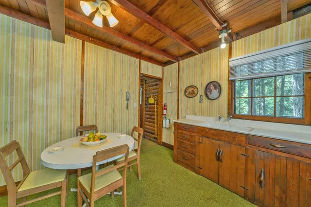 a dining room with stainless steel appliances a table and chairs