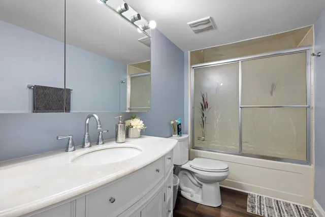 a bathroom with a granite countertop sink toilet and shower