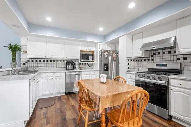 a kitchen with stainless steel appliances kitchen island granite countertop a sink stove and refrigerator