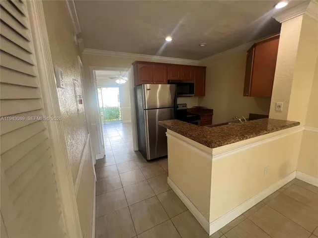 an empty room with chandelier fan and windows