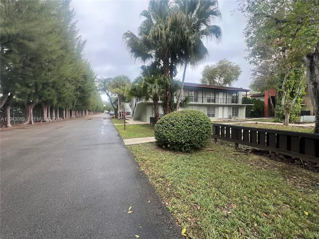 a view of a house with a backyard and trees