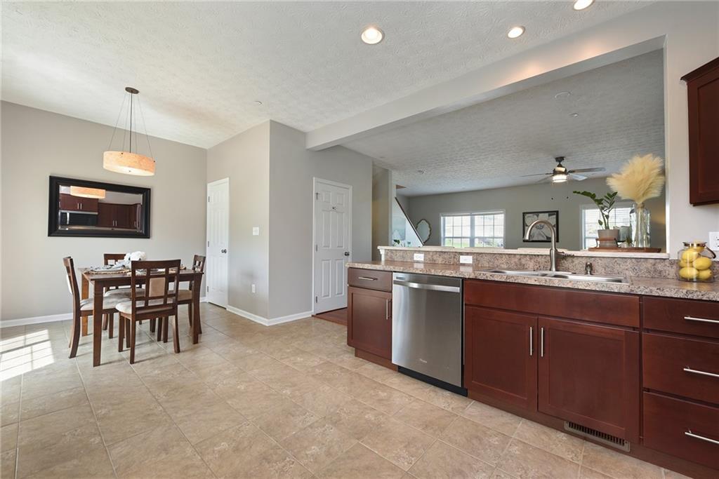 703 Freedom Drive Pittsburgh, PA 15205 - Photo 12 of 42 a kitchen with stainless steel appliances granite countertop a sink a stove a dining table and chairs