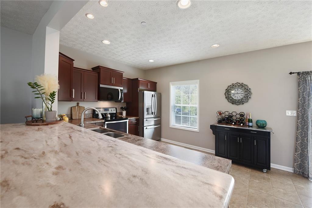 703 Freedom Drive Pittsburgh, PA 15205 - Photo 8 of 42 a kitchen with stainless steel appliances kitchen island granite countertop a stove refrigerator and cabinets