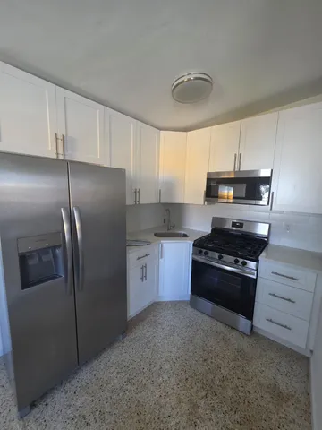 a kitchen with granite countertop a refrigerator and a stove