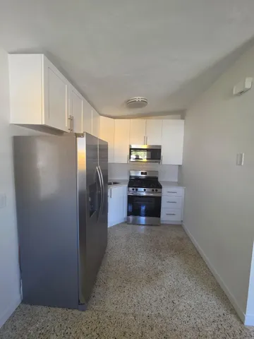 a kitchen with stainless steel appliances a refrigerator and window