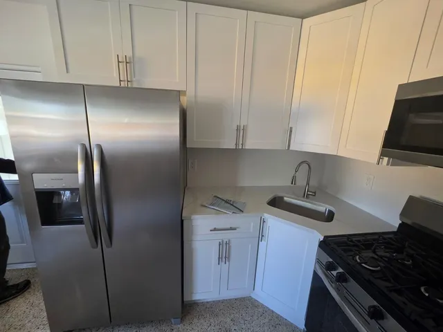 a kitchen with stainless steel appliances granite countertop a sink stove and refrigerator