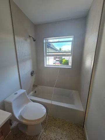 a bath room with a toilet and a bath tub