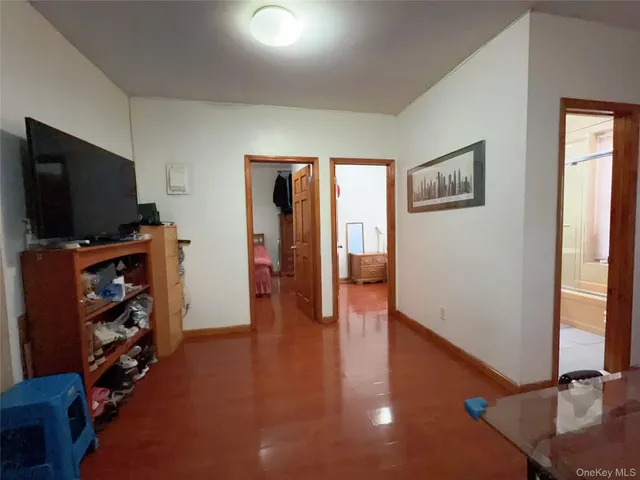 a view of a livingroom with wooden floor and a flat screen tv