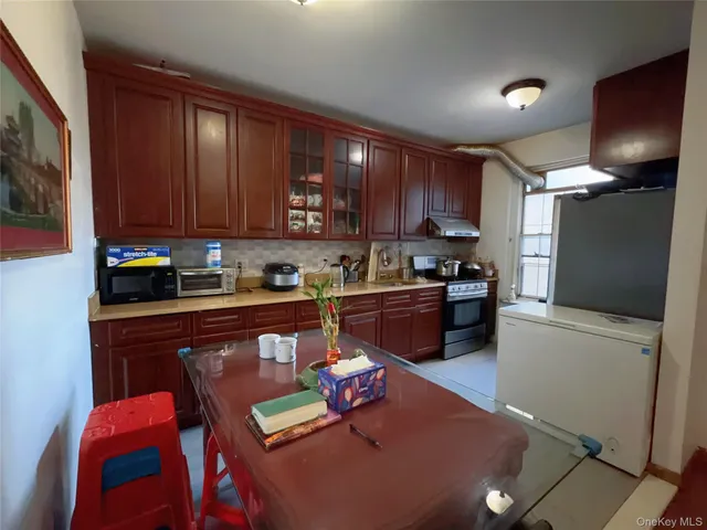 a kitchen with a refrigerator a stove top oven a sink and cabinets