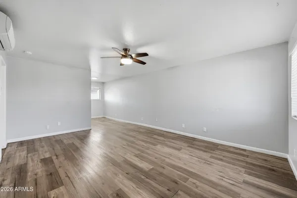 a view of an empty room with wooden floor