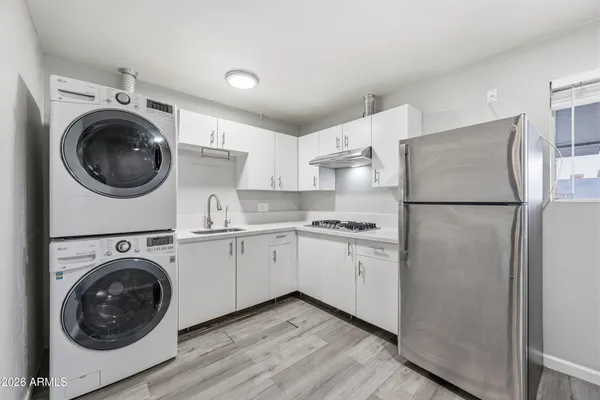a kitchen with cabinets washer and dryer
