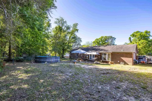 a view of a house with backyard and sitting area
