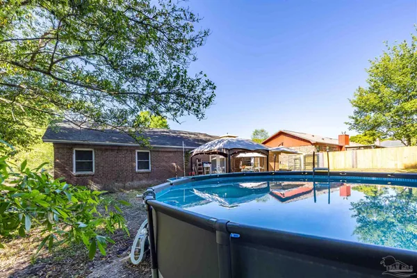 a view of a house with pool and chairs