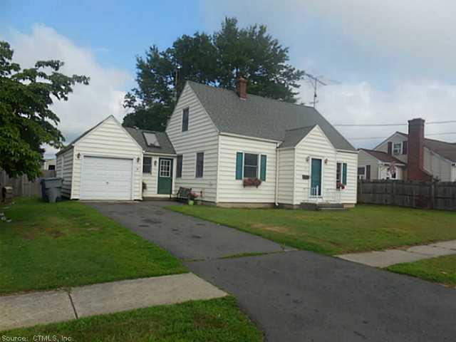 a view of a yard in front of a house with plants and large tree