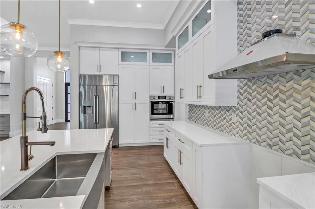 733 15th Street Southwest Naples, FL 34117 - Photo 11 of 34 a kitchen with granite countertop a refrigerator and a sink