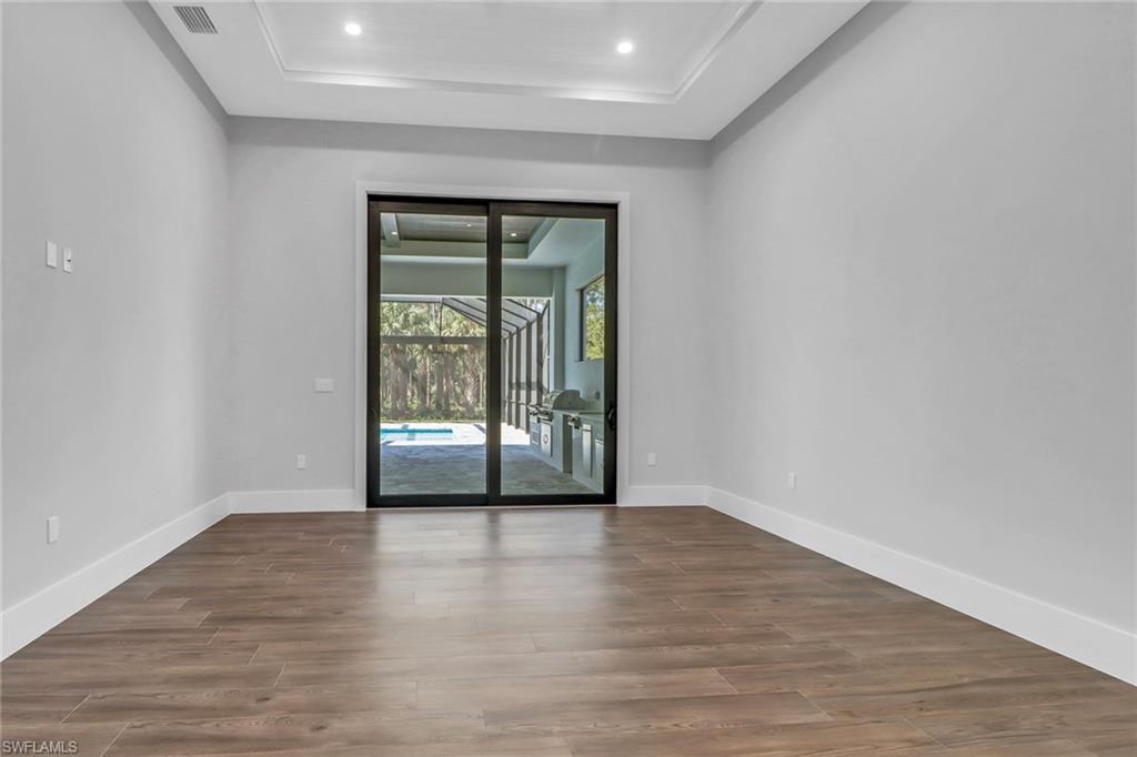 733 15th Street Southwest Naples, FL 34117 - Photo 16 of 34 wooden floor in an empty room with a window