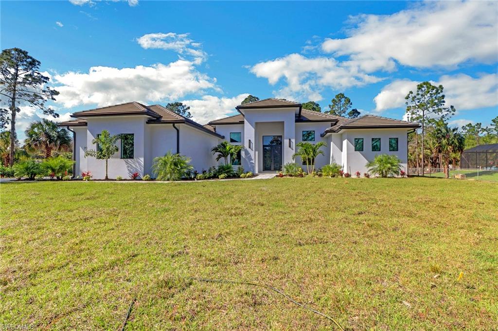 733 15th Street Southwest Naples, FL 34117 - Photo 2 of 34 a front view of house with yard and trees around