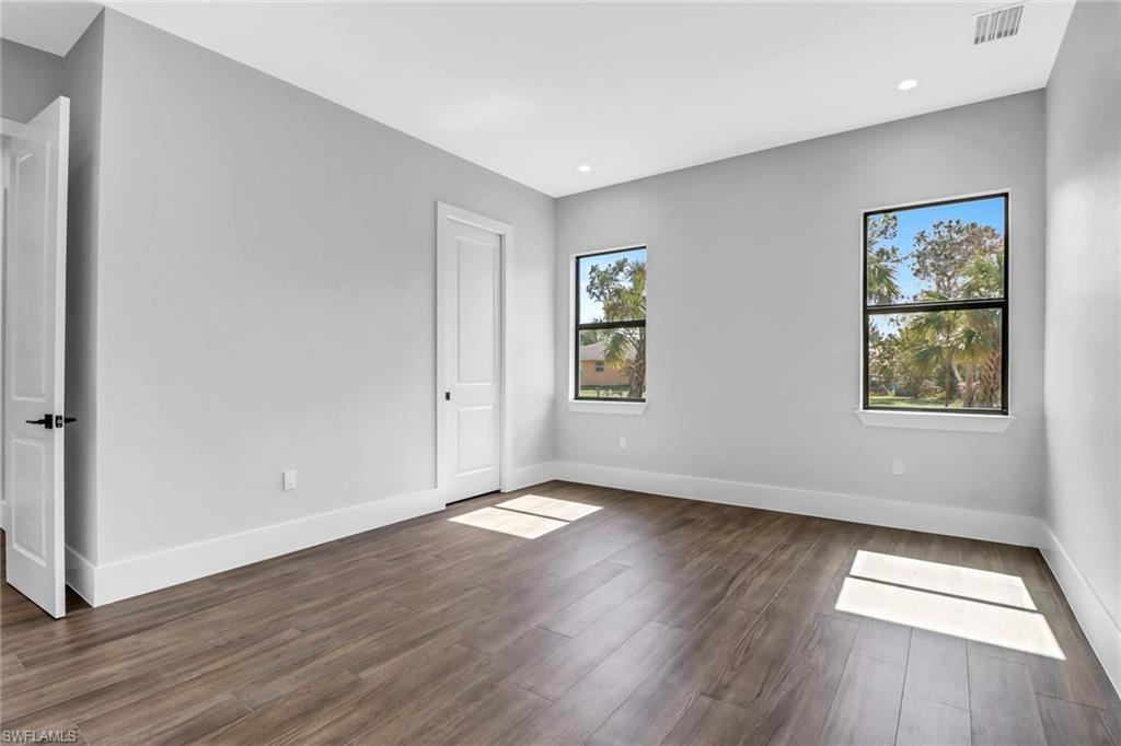 733 15th Street Southwest Naples, FL 34117 - Photo 27 of 34 an empty room with wooden floor and windows