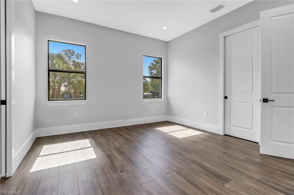 733 15th Street Southwest Naples, FL 34117 - Photo 29 of 34 an empty room with wooden floor and windows