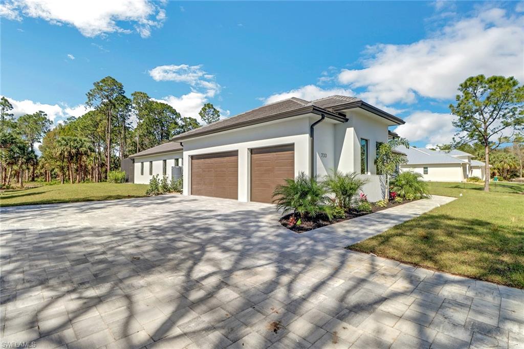 733 15th Street Southwest Naples, FL 34117 - Photo 3 of 34 a front view of a house with a yard