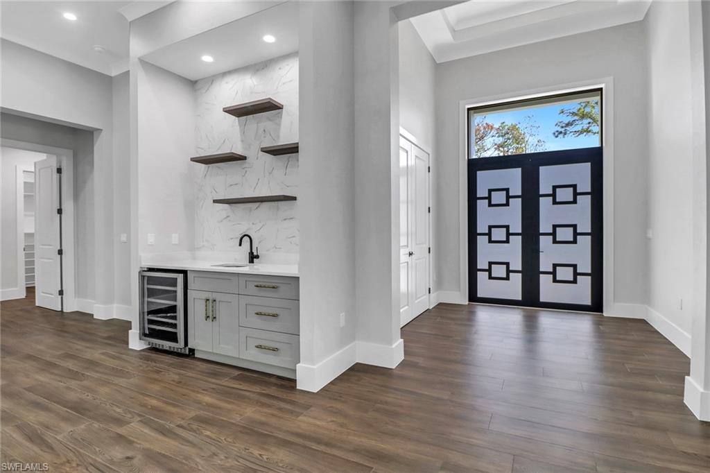 733 15th Street Southwest Naples, FL 34117 - Photo 4 of 34 a view of a hallway with wooden floor and cabinet