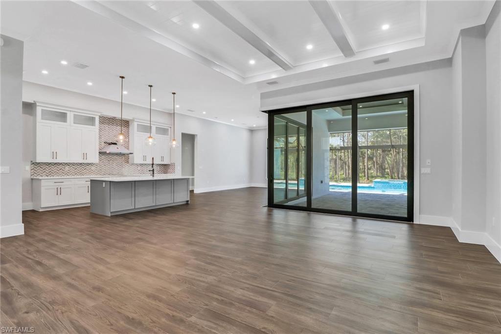 733 15th Street Southwest Naples, FL 34117 - Photo 6 of 34 a view of an empty room with wooden floor and a large window