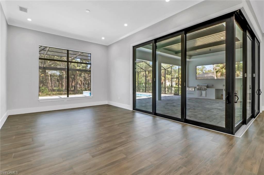 733 15th Street Southwest Naples, FL 34117 - Photo 8 of 34 wooden floor in an empty room with a window
