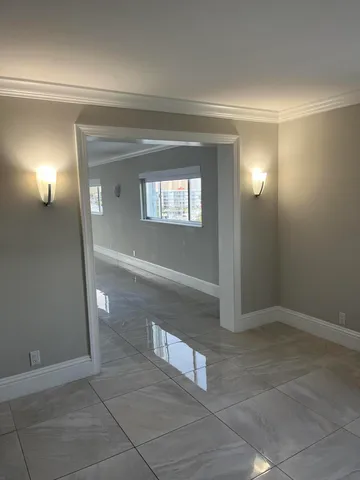 an empty room with windows and cabinet