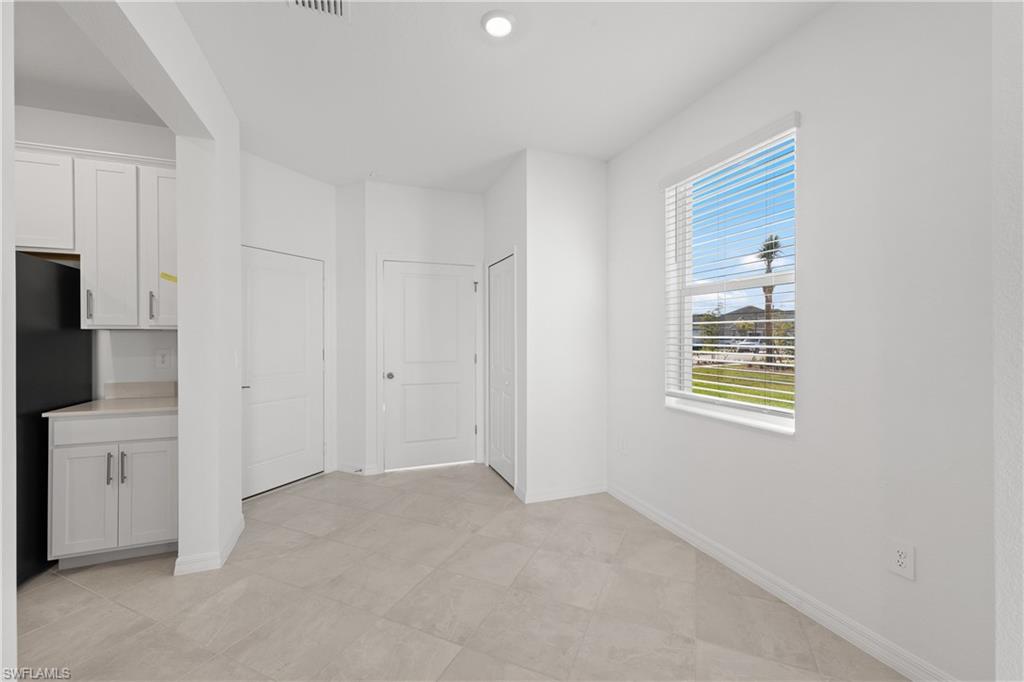 14792 Bluewater Road Babcock Ranch, FL 33982 - Photo 12 of 42 a view of an empty room with a kitchen and a window