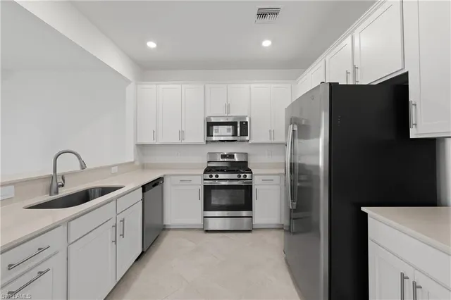 a kitchen with stainless steel appliances granite countertop a refrigerator sink and stove