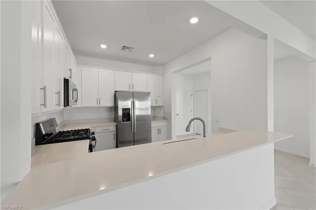 a kitchen with refrigerator and cabinets
