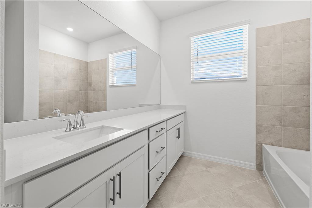 14792 Bluewater Road Babcock Ranch, FL 33982 - Photo 33 of 42 a bathroom with a sink a vanity and a bathtub
