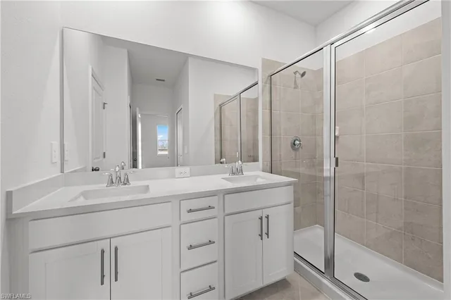 a bathroom with a shower sink vanity granite and mirror