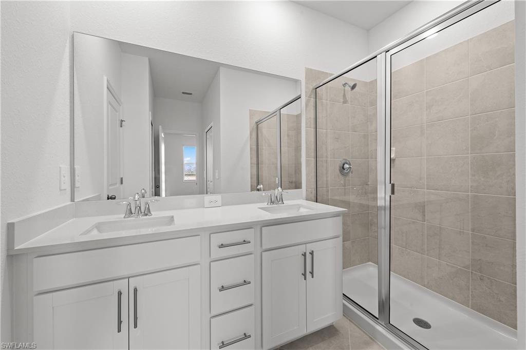14792 Bluewater Road Babcock Ranch, FL 33982 - Photo 42 of 42 a bathroom with a shower sink vanity granite and mirror